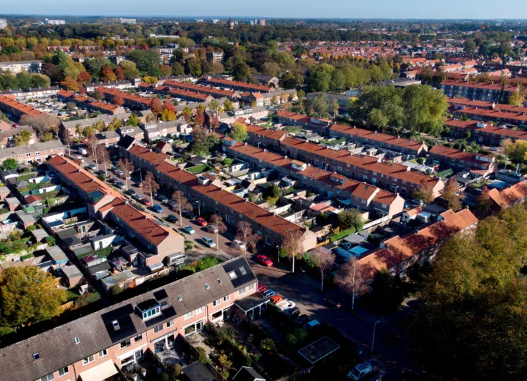 Luchtfoto van een wijk met rijtjeshuizen met rode daken