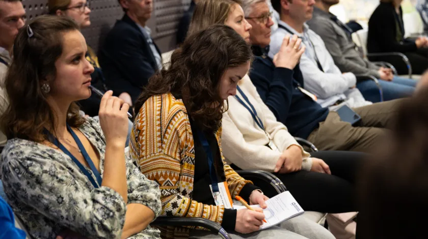 groep deelnemers aan congres luistert aandachtig toe tijdens een van de workshops
