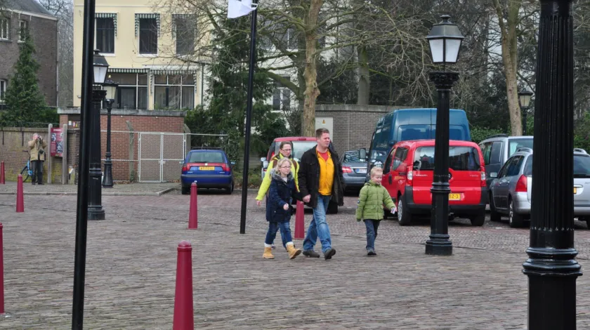 Ouders met 2 kinderen wandelen over een verlaten plein