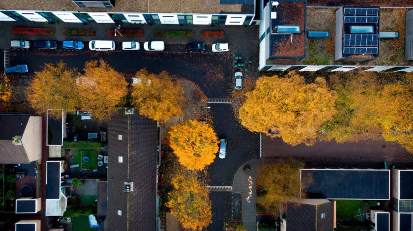 Straatbeeld Tilburg van bovenaf gefotografeerd.  Zichtbaar zijn enkele boomkruinen en appartementgebouwen