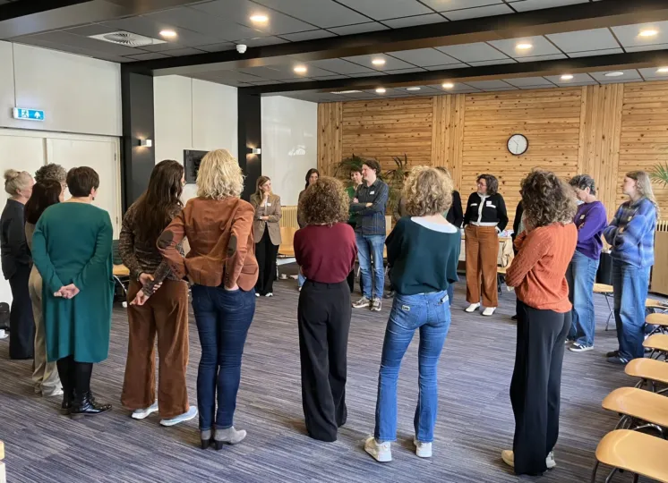 Deelnemers staan in een kring tijdens een workshop