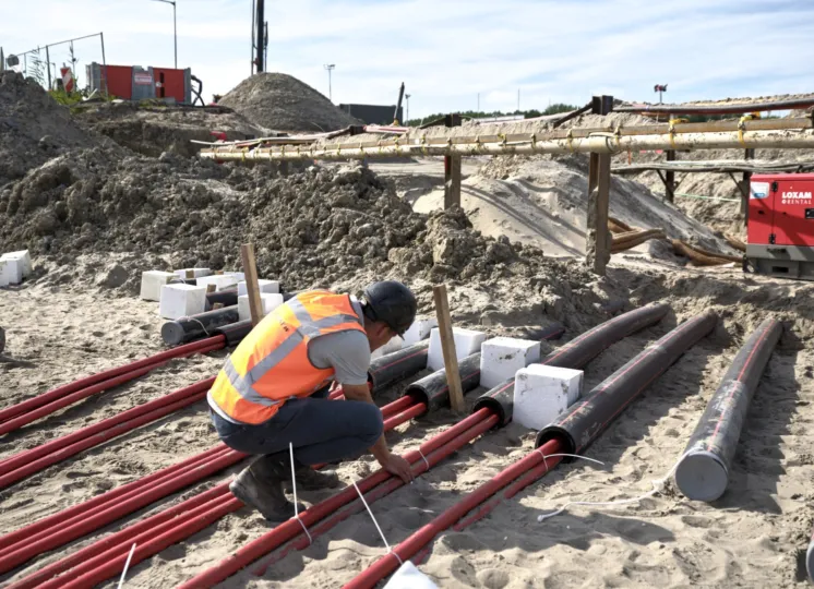 Een man installeert kabelverbindingen op een bouwterrein
