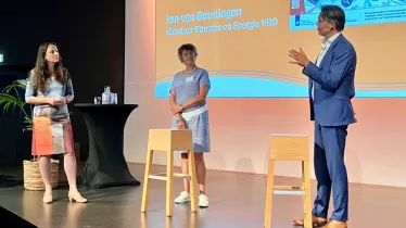 Programmadirecteur Maureen van Eijk van NPLW en directeur Bouwen en Energie Jan van Beuningen van VRO worden ondervraagd op het podium tijdens de Impulsdag Isoleren