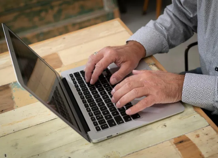 Een man werkt op zijn laptop