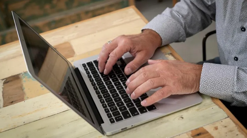 Een man werkt op zijn laptop