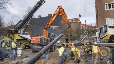 Bouwvakkers leggen warmtenetbuizen aan