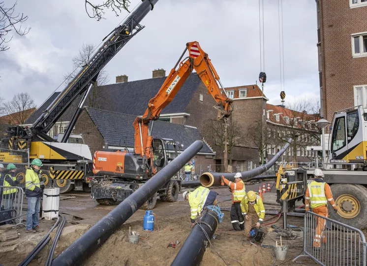 Bouwvakkers leggen warmtenetbuizen aan