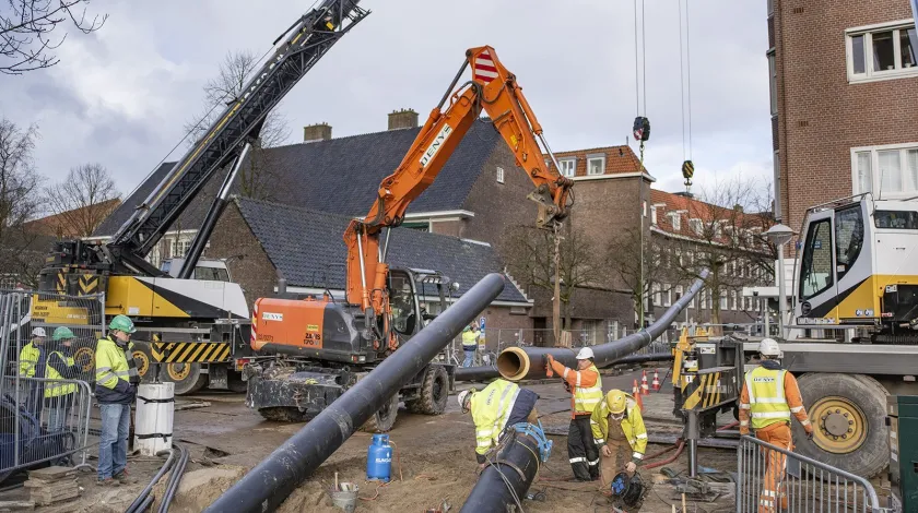 Bouwvakkers leggen warmtenetbuizen aan